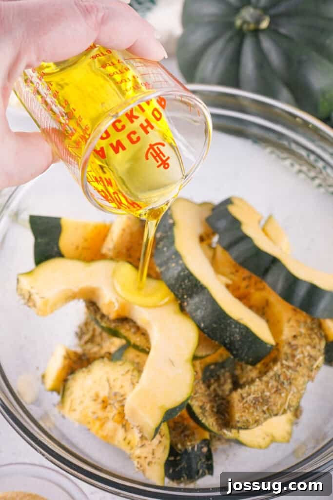 Caramelized Acorn Squash 7 Olive oil being poured over acorn squash slices in a mixing bowl with herbs and spices.