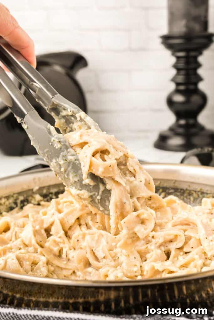 tongs picking up pasta from pan