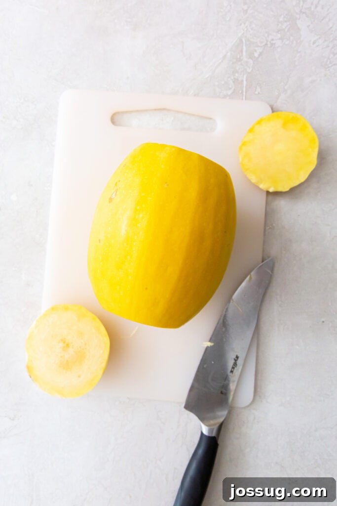 Spaghetti squash with the ends cut off sitting on a cutting board beside a knife.