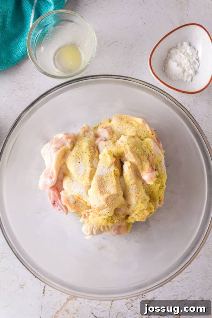 Crispy Air Fryer Lemon Pepper Wings 7 Chicken wings in a bowl sprinkled with lemon pepper seasoning mix.
