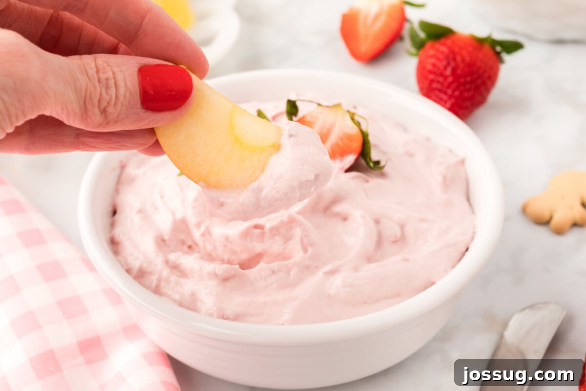 apple slice being dipped into strawberry dip