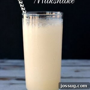 A vibrant Hawaiian Delight Milkshake in a tall glass, adorned with tropical garnishes, ready to be served.