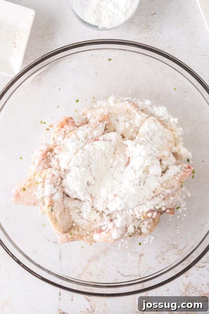 Crispy Air Fryer Ranch Wings 8 Chicken wings sprinkled with cornstarch in a glass bowl before tossing