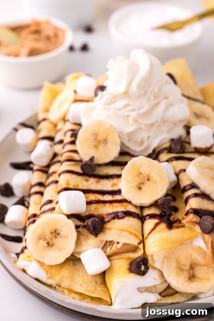 Decadent Banana Fluffernutter Crepes 2 Closeup of golden banana fluffernutter crepes beautifully arranged on a white plate, ready to be enjoyed.