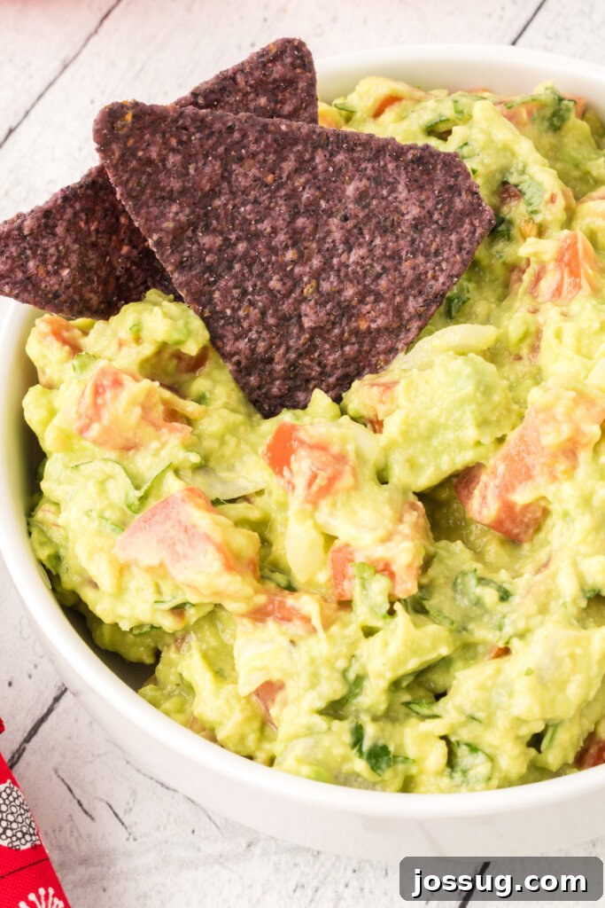 Delicious homemade guacamole in a bowl with tortilla chips.