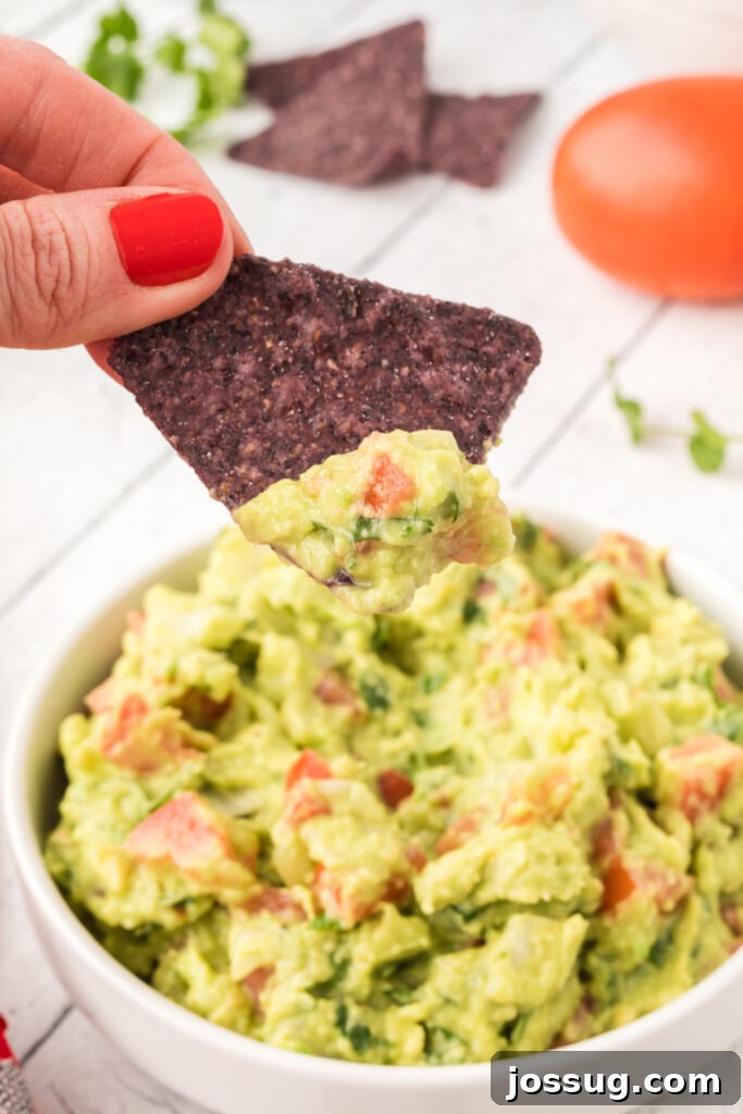 Tortilla chips scooping up a generous serving of homemade guacamole.