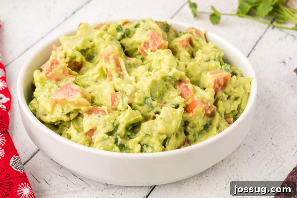 A pristine white bowl filled to the brim with creamy homemade guacamole.