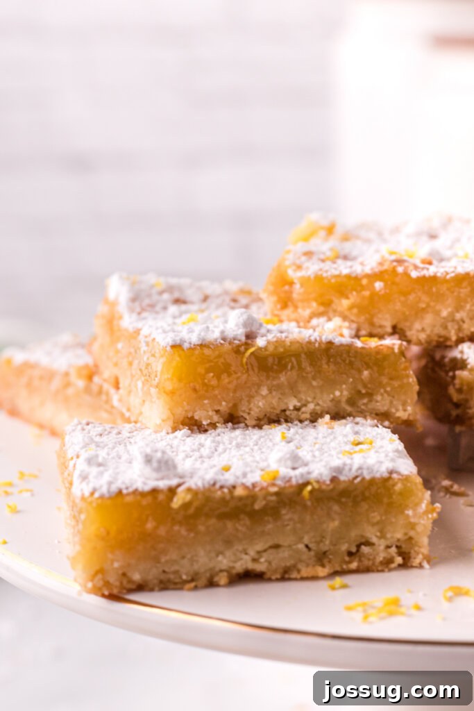 Close-up view of freshly baked lemon bars, showcasing their golden crust and vibrant yellow filling.
