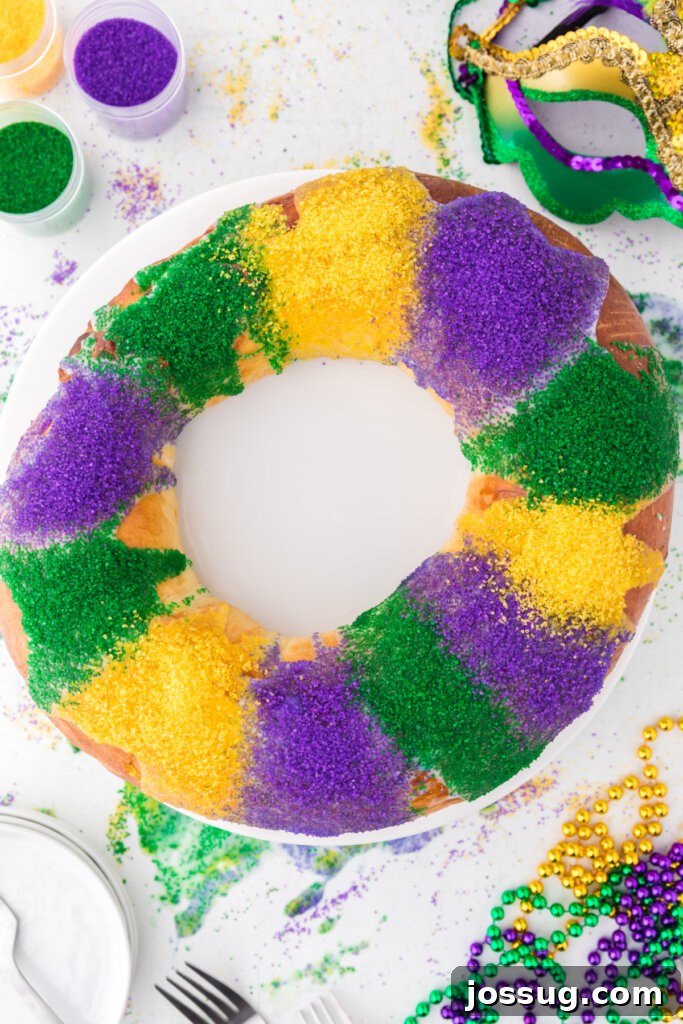 New Orleans Mardi Gras King Cake 2 A vibrant and festive New Orleans King Cake, seen from above, decorated with purple, green, and gold sugar