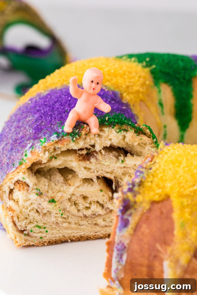 New Orleans Mardi Gras King Cake 3 A close-up view of a King Cake slice, revealing the hidden plastic baby figurine, symbolizing good luck for the finder.