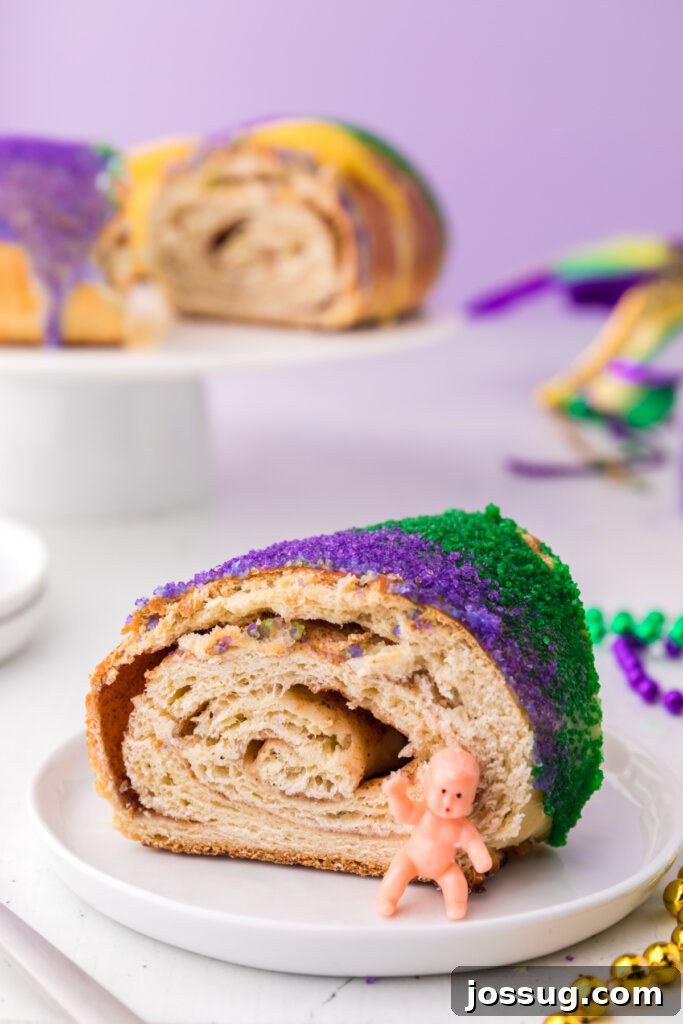New Orleans Mardi Gras King Cake 4 A slice of New Orleans King Cake on a plate, showcasing its colorful sugar decoration and fluffy texture, ready for Mardi Gras.