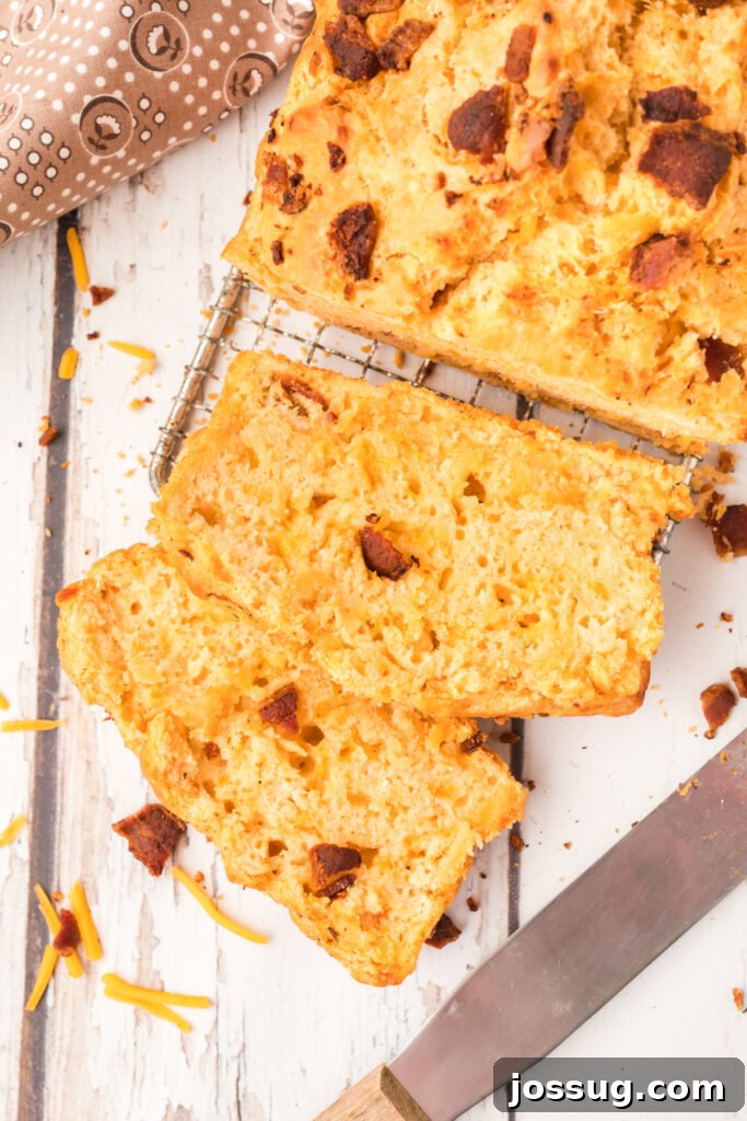 Smoked Bacon & Cheddar Ale Loaf 2 slices of bacon cheddar beer bread cut from loaf, showcasing crispy bacon and melted cheddar cheese