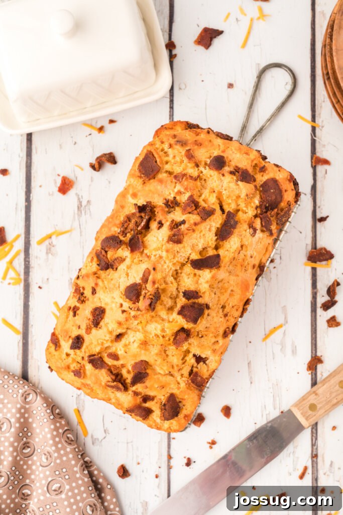 Smoked Bacon & Cheddar Ale Loaf 3 overhead view of a freshly baked loaf of bacon cheddar beer bread, golden and inviting