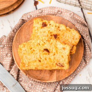 two slices of bacon cheddar beer bread on wooden plate
