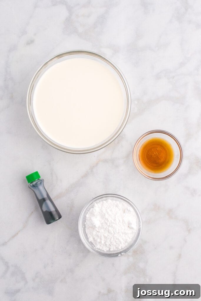 Biohazard Brew 4 Bowls of heavy cream, powdered sugar, vanilla extract, and green food coloring arranged on a clean marble countertop, prepared for making the foamy topping.
