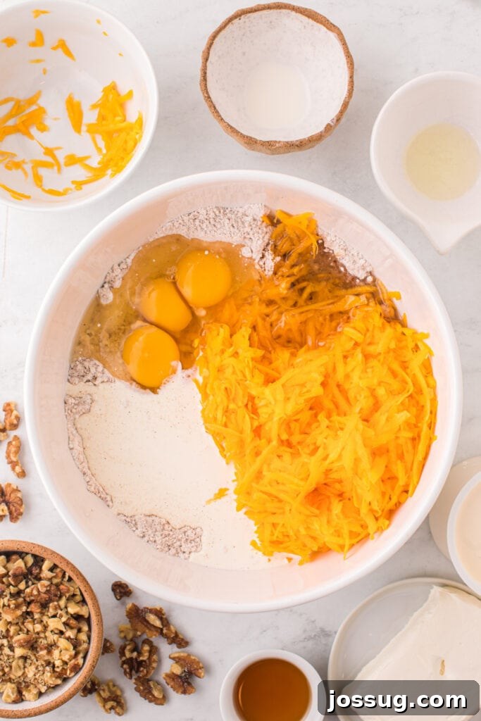 Spiced Golden Butternut Cake 5 A generous mixing bowl contains the wet ingredients – grated butternut squash, eggs, oil, and cream – alongside the dry cake mix, all poised to be perfectly combined.