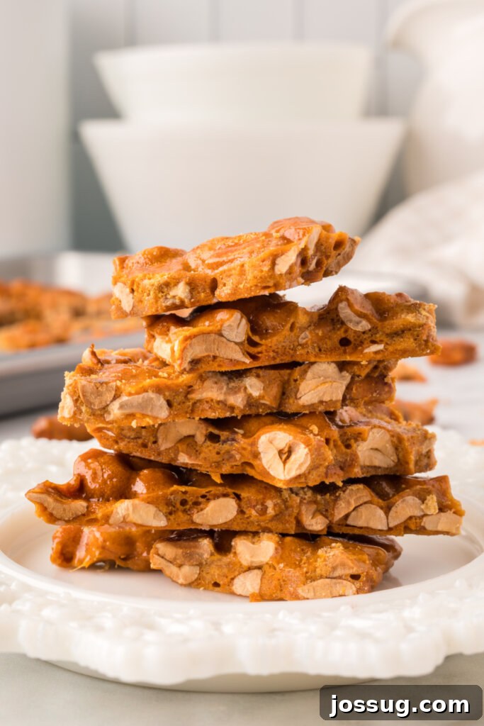 Stacked pieces of golden microwave peanut brittle on a festive plate, ready to be enjoyed.
