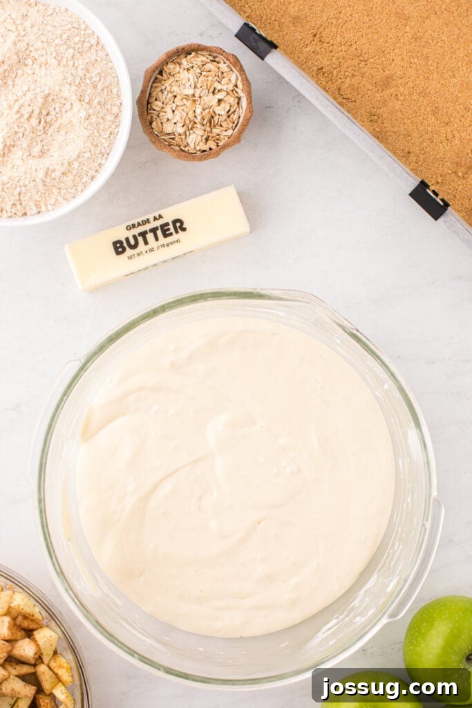 Smooth cheesecake batter in a glass bowl, showcasing a silky consistency, ready to be poured over the crust.