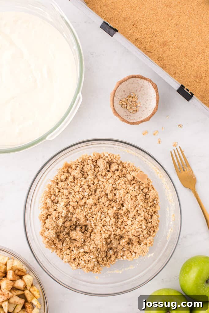 Crumb topping mixture in a glass bowl after mixing, appearing crumbly and ready to sprinkle over the cheesecake and apples.