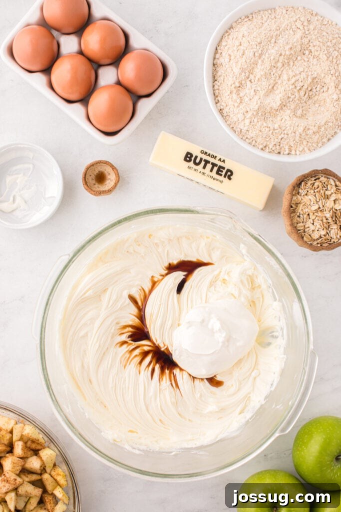 Cream cheese mixture with sour cream and vanilla extract added on top, before final mixing for the cheesecake filling.