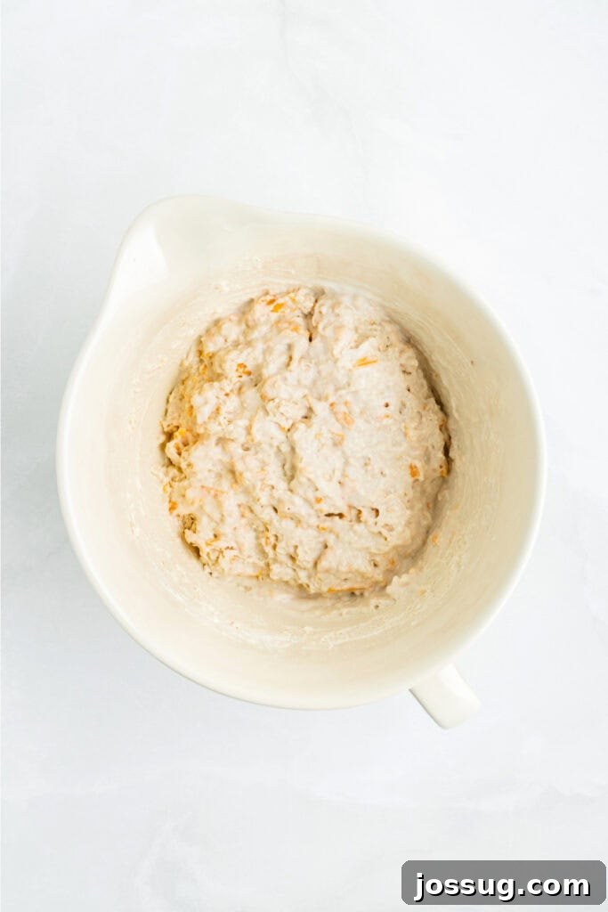 Biscuit dough mixed until just combined, showing a soft, slightly lumpy texture that indicates it's not overmixed.
