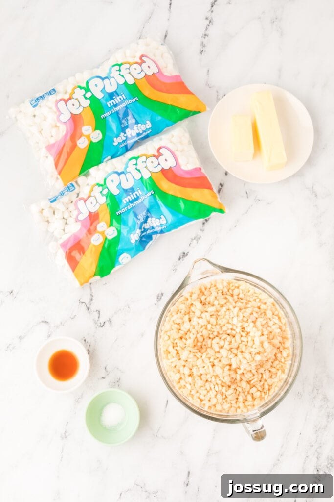 Caramelized Butter Rice Crisps 3 Ingredients for Browned Butter Rice Crispy Treats including mini marshmallows, butter sticks, crispy rice cereal, vanilla extract, and salt on a marble surface.