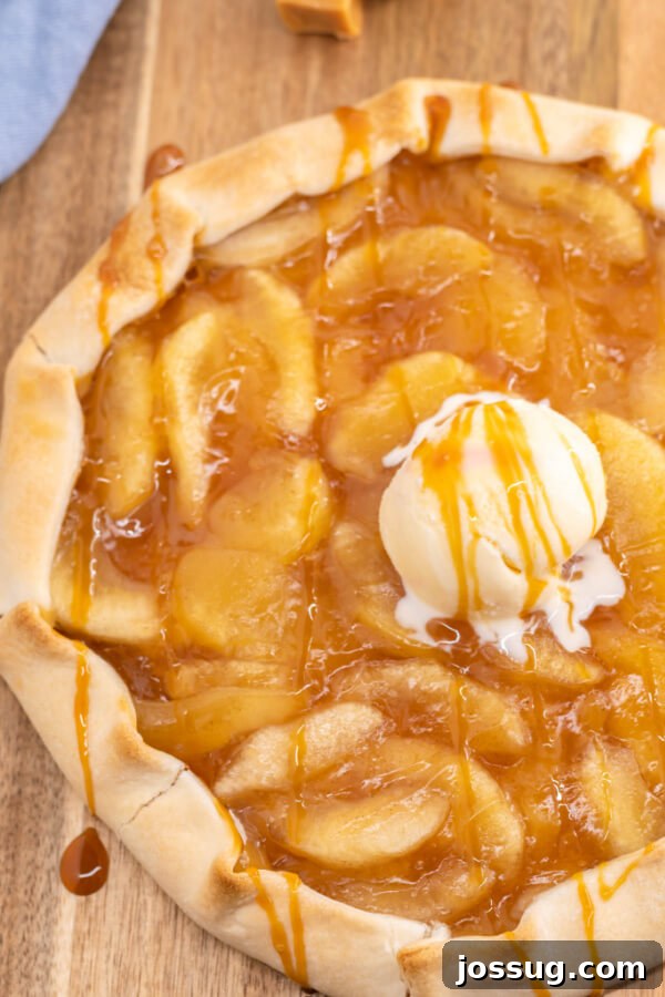Looking down onto a finished Caramel Apple Galette with a scoop of vanilla ice cream, ready to be served.