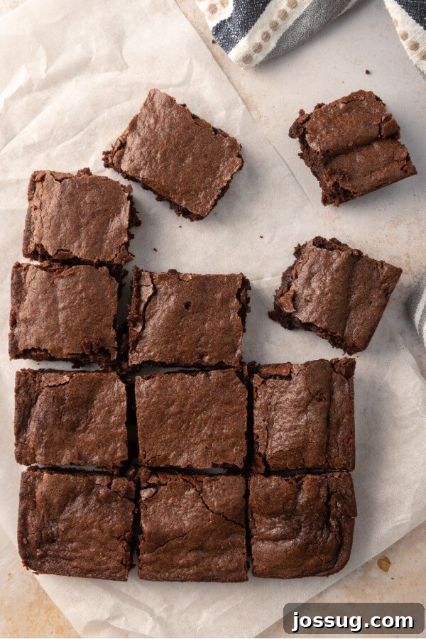 Foolproof Homemade Chocolate Brownies 6 Perfectly cut squares of fudgy brownies cooling on parchment paper