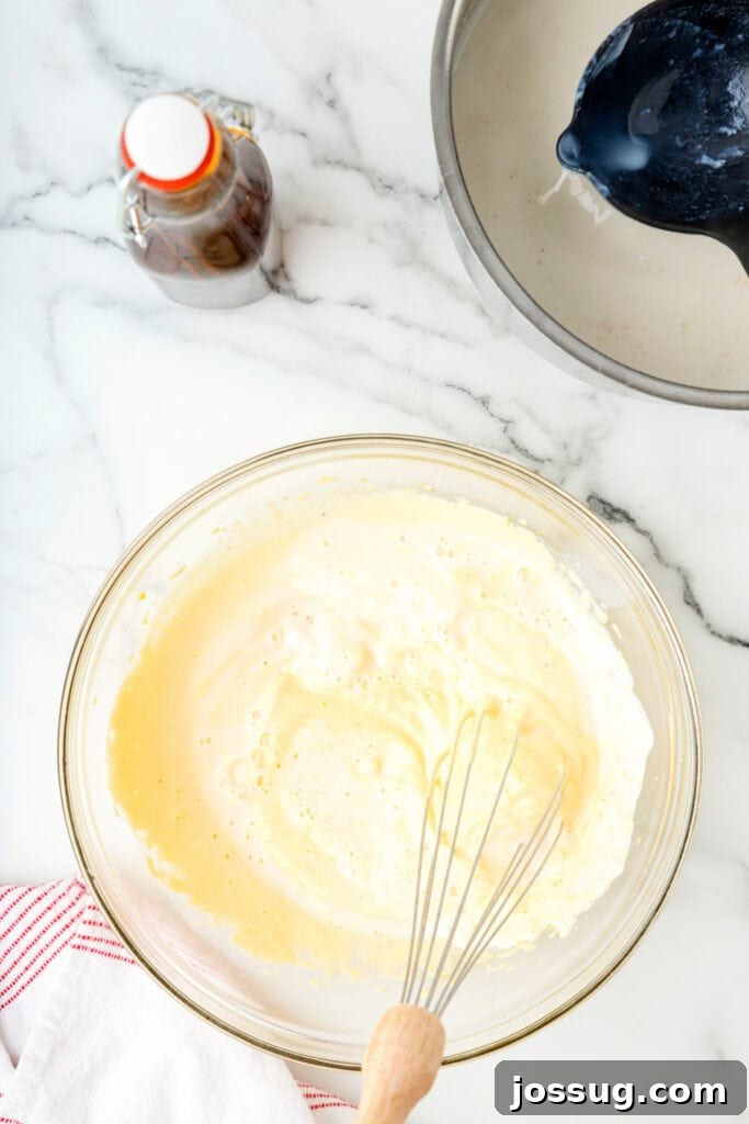 Classic Homemade Eggnog 12 Eggnog mixture in a glass bowl after combining milk and egg yolks, ready to cook further.
