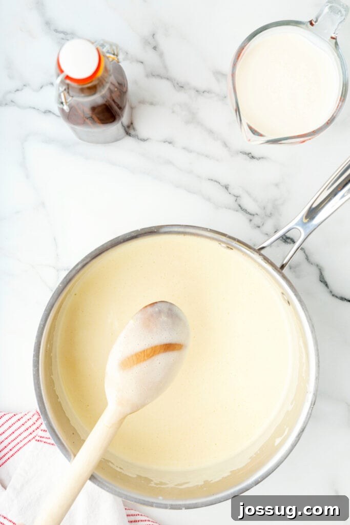 Classic Homemade Eggnog 15 Eggnog mixture in saucepan with wooden spoon showing the line test for coating thickness.