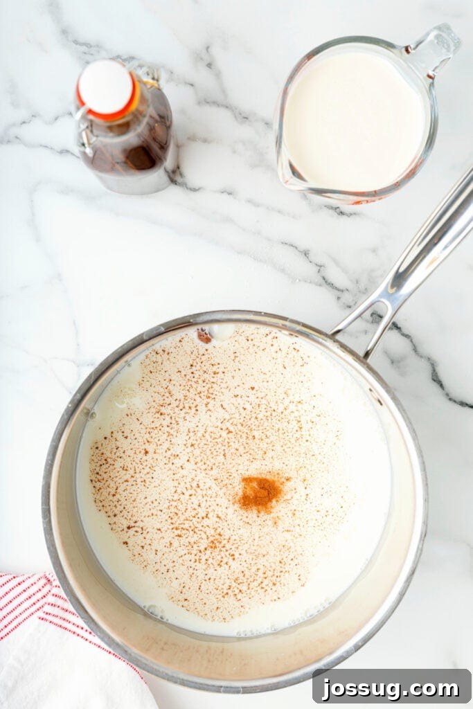 Classic Homemade Eggnog 9 Spiced milk simmering in a saucepan with ground nutmeg and cinnamon on top.