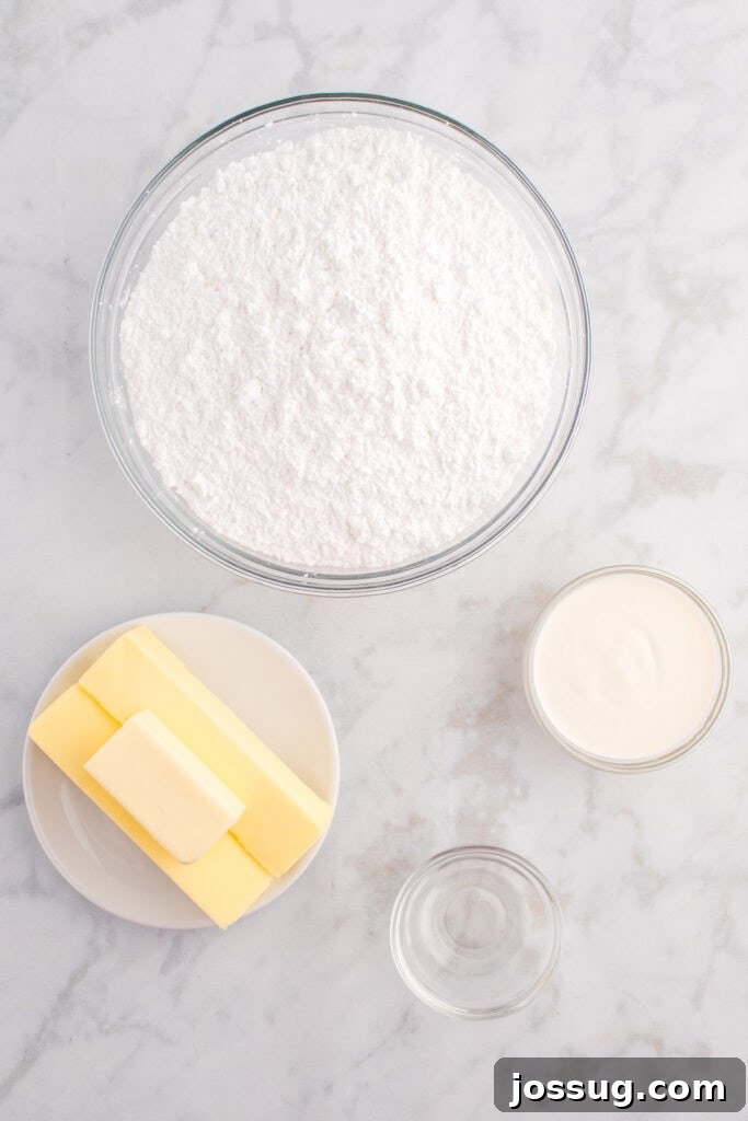 Overhead view of frosting ingredients including powdered sugar, butter, cream, and clear vanilla extract in glass bowls.