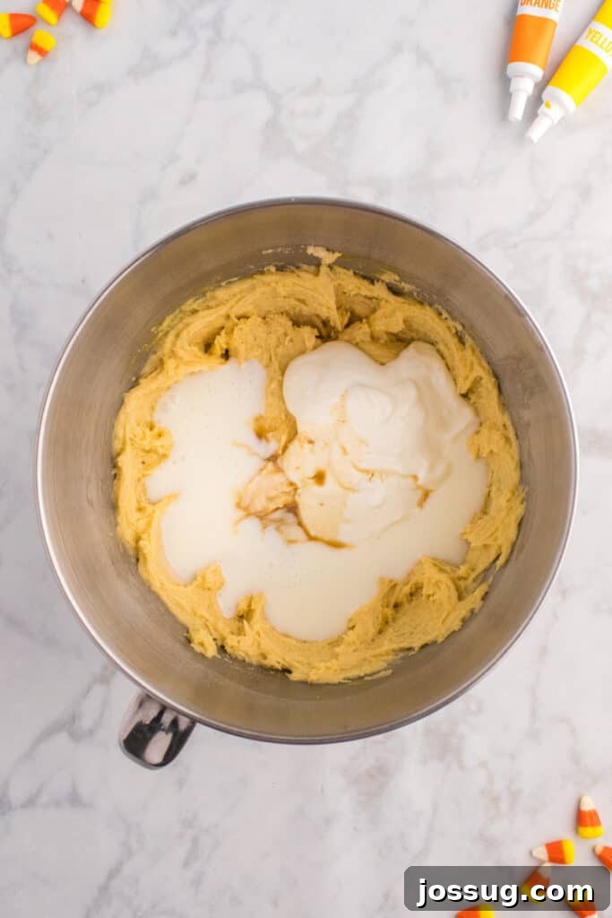 Batter in mixing bowl with Greek yogurt, buttermilk, and vanilla extract added on top before final mixing.