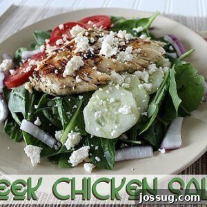A colorful Greek Chicken Salad with grilled chicken, spinach, tomatoes, cucumbers, and feta cheese.