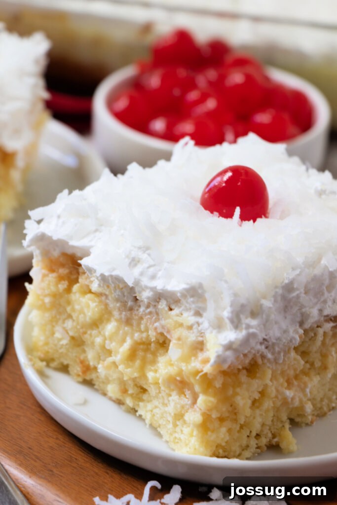 Piña Colada Paradise Cake 2 Piña Colada Poke Cake slice on a white plate