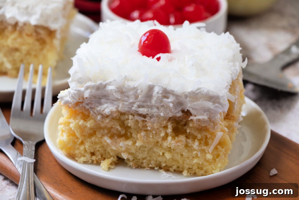 Piña Colada Paradise Cake 4 A slice of Piña Colada Poke Cake on a plate