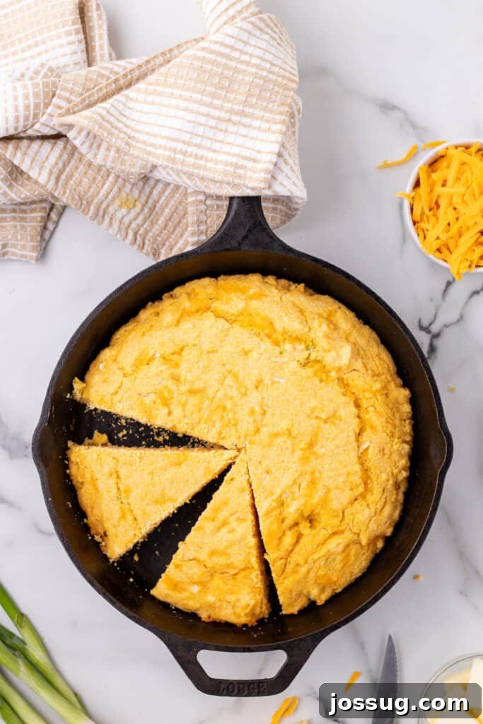 Savory Cheddar Onion Cornbread 12 Sliced Cheddar Onion Cornbread in a cast iron skillet showing golden edges and a soft crumb.