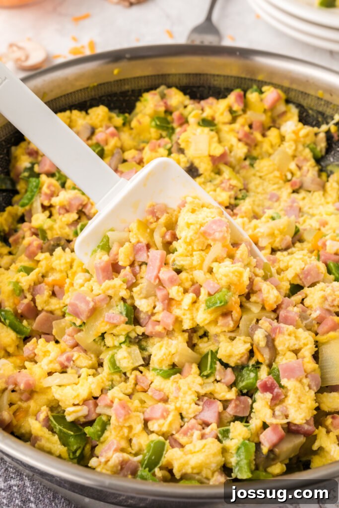 Denver Scramble 3 Denver Omelet Scramble cooking in a skillet, showcasing the colorful ingredients.