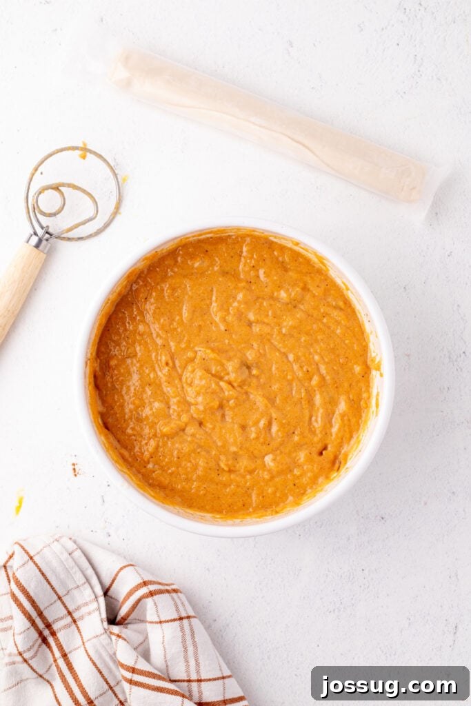 Sunshine Sweetness Pie 5 Smooth orange sweet potato pie filling in a white bowl after whisking ingredients together.
