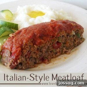 Tuscan Meatloaf 2 A slice of Italian-Style Meatloaf on a white plate, served with cooked zucchini and creamy mashed potatoes topped with butter.