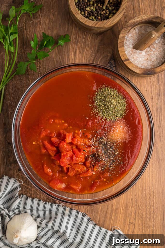 Mixing bowl filled with tomato sauce, diced tomatoes, and seasonings ready to be whisked together for the Cabbage Rolls sauce.