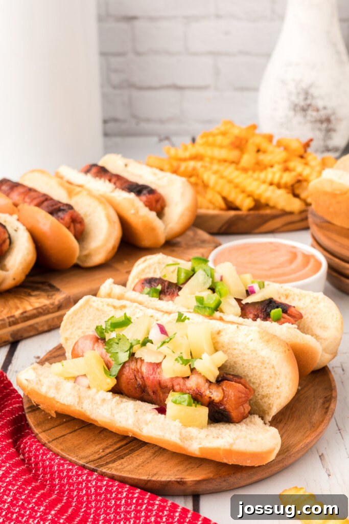 Hawaiian hot dogs cooked and ready to eat, garnished with fresh pineapple salsa