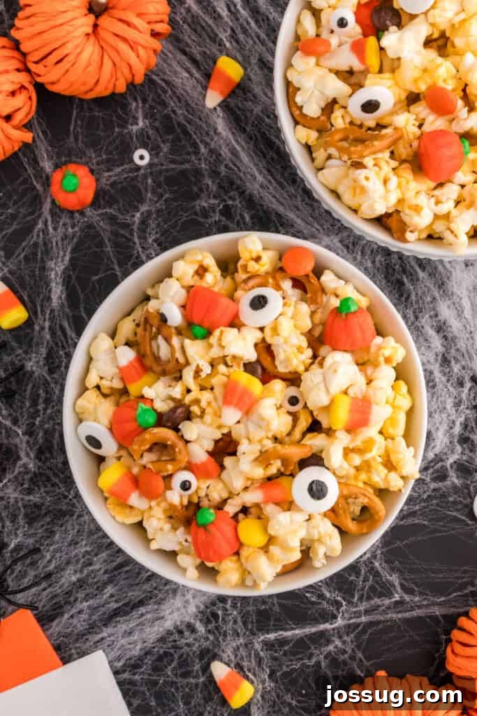 Monster Munch Popcorn 8 Two bowls of Monster Mash Popcorn with candy eyeballs and pumpkins on a Halloween-themed background.