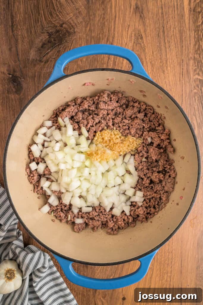 Finely chopped onions and minced garlic added to the browned meat in the dutch oven, beginning to soften.