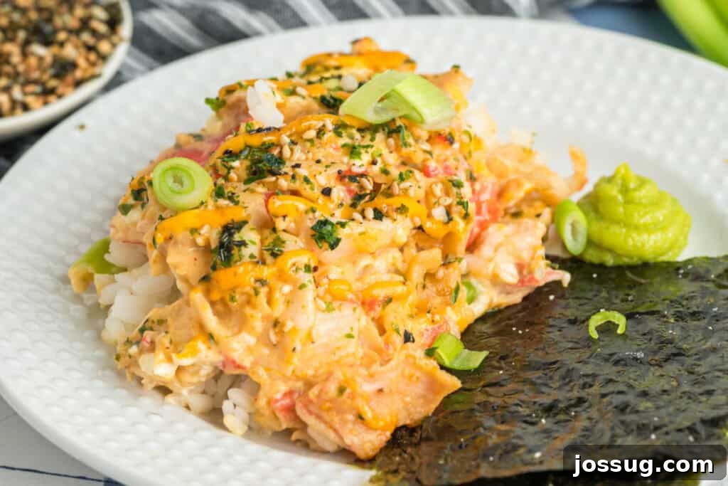 Homemade Sushi Bake Delight 16 Sushi bake served with nori and wasabi on a white plate, topped with green onions and sesame seasoning.