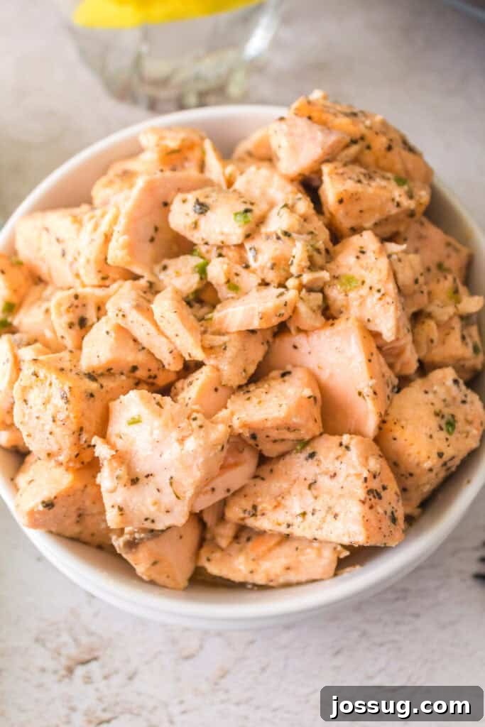Overhead shot of a bowl of air fryer salmon bites garnished with fresh herbs, ready to serve.