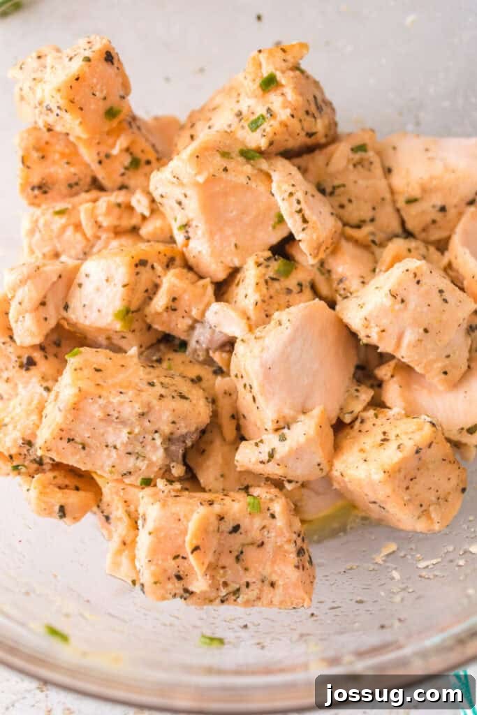 Close-up of salmon bites coated in garlic butter and herbs, showing tender flaky texture.