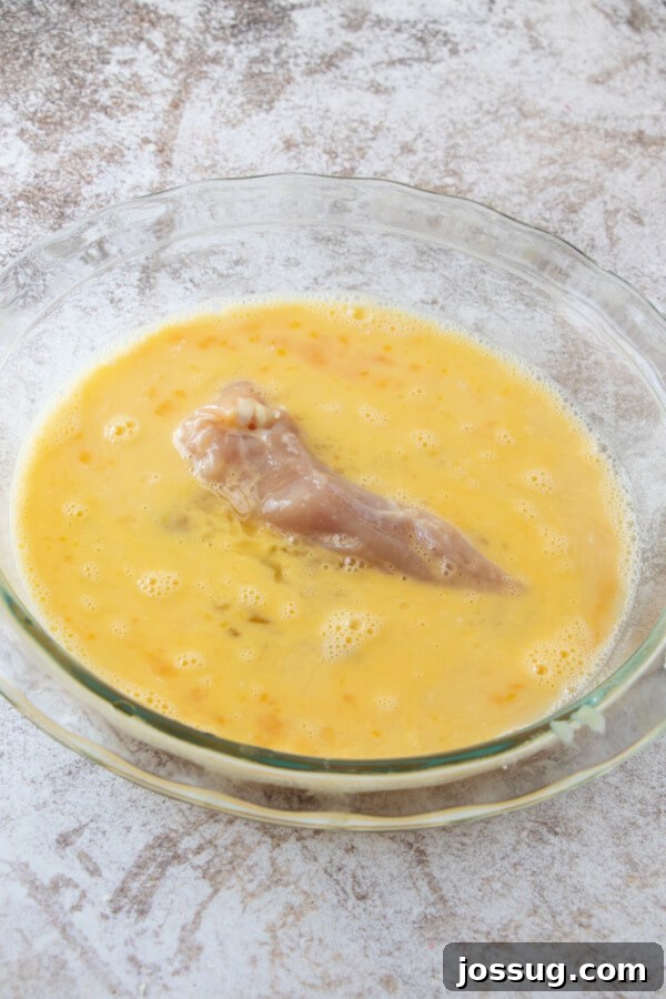 Coating the chicken strips in egg wash