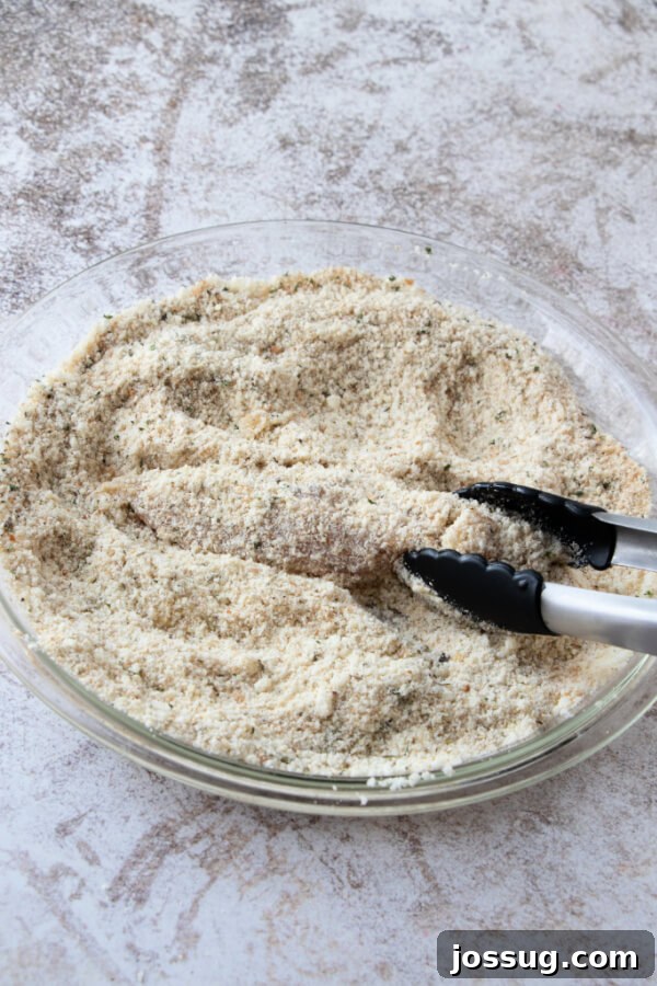 Coating the chicken strips in breadcrumb and parmesan mixture