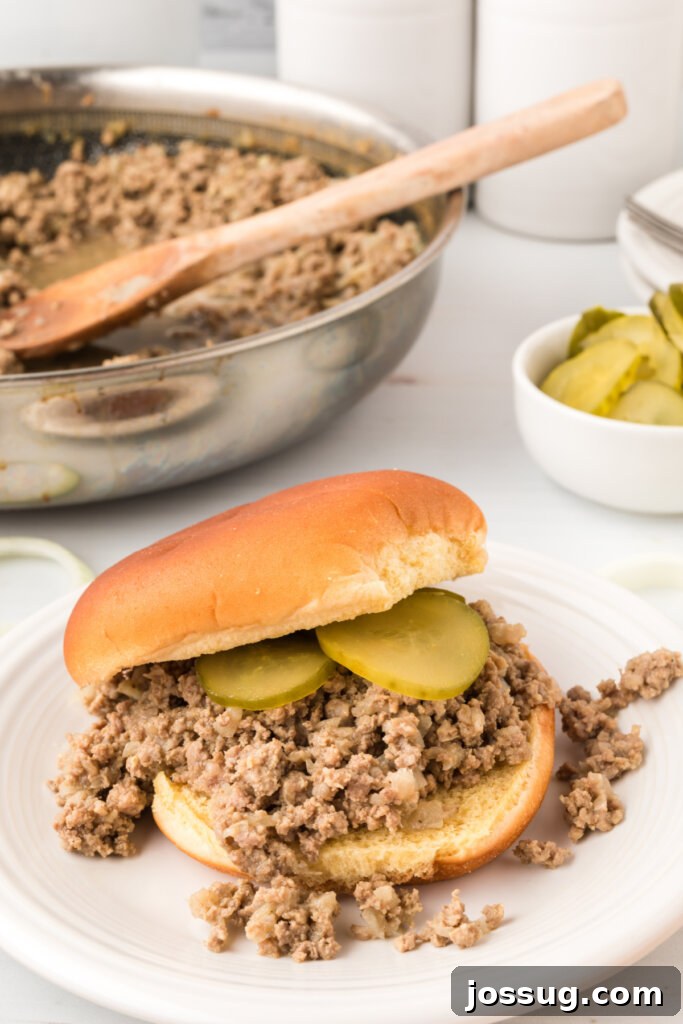 A perfectly prepared loose meat sandwich on a plate, ready to be enjoyed.